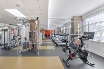 A gym with a variety of equipment including treadmills, weights, and exercise bikes.